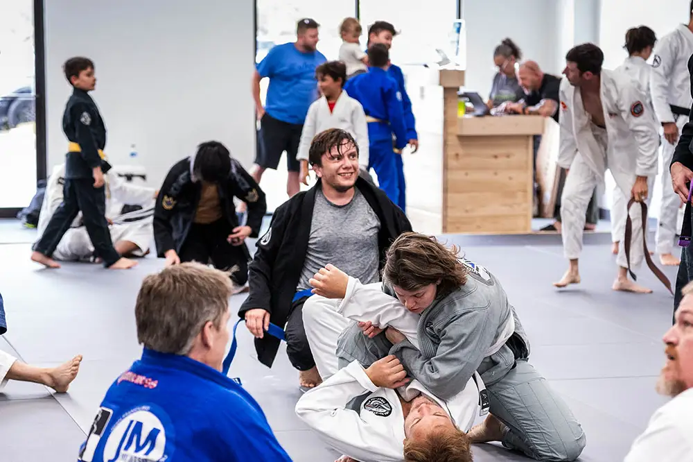 A group of jiu jitsu students in a positive environment with everyone smiling at Raposo BJJ Academy in Slidell LA