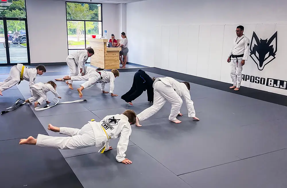 A group of kids drilling jiu jitsu techniques during a class at Raposo BJJ Academy in Slidell LA